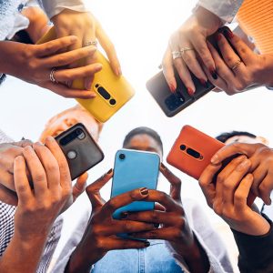 View looking up at five people with their faces obscured by colorful smart phones